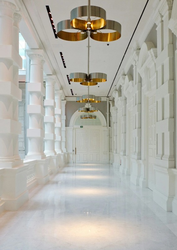 Colonnaded corridor with brass pendant lights